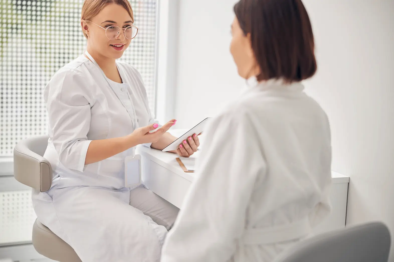 Skincare specialist consulting a client about Platelet-Rich Plasma Therapy treatment plan.