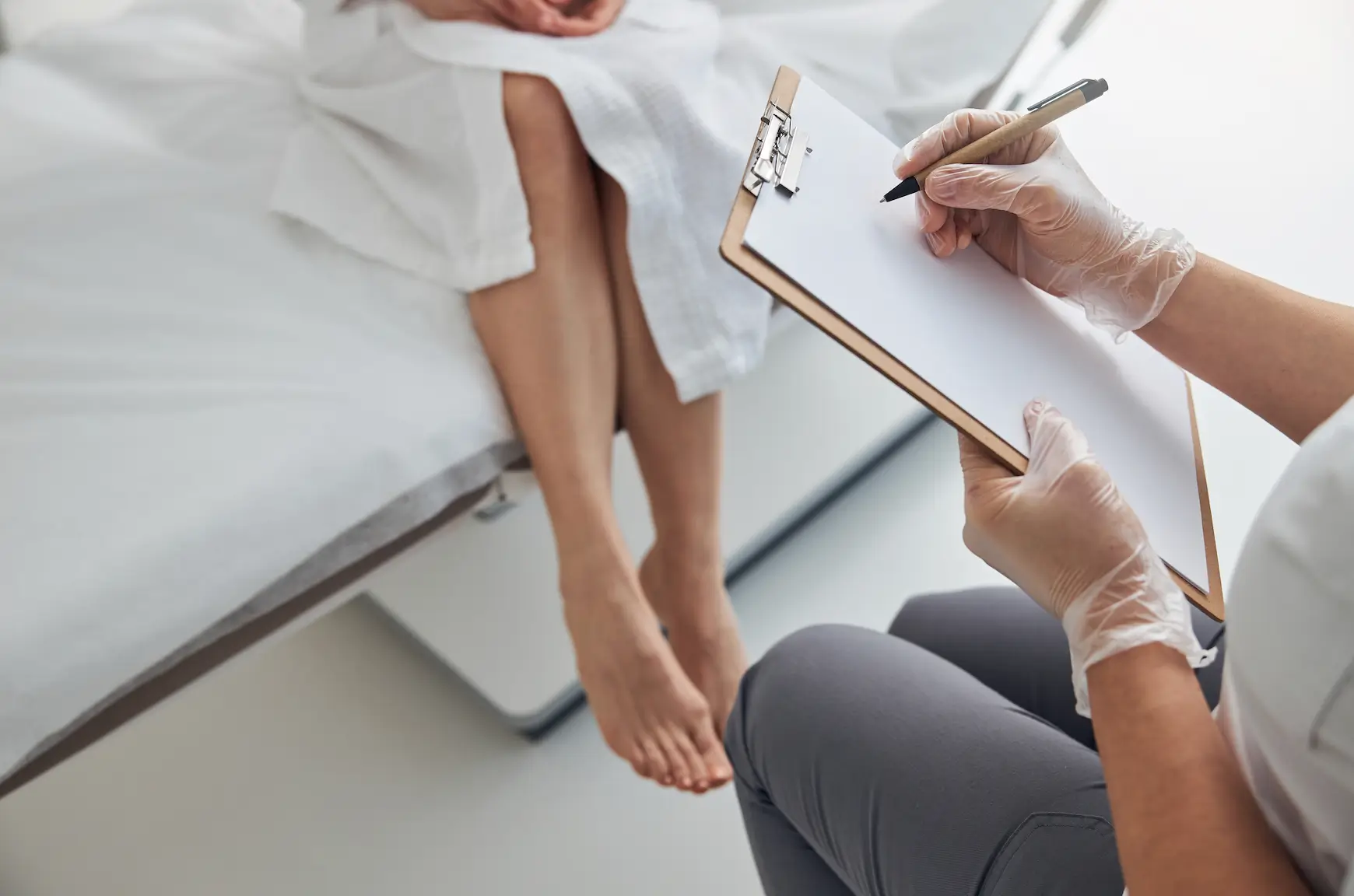 Doctor consulting patient and taking notes before Sclerotherapy procedure.